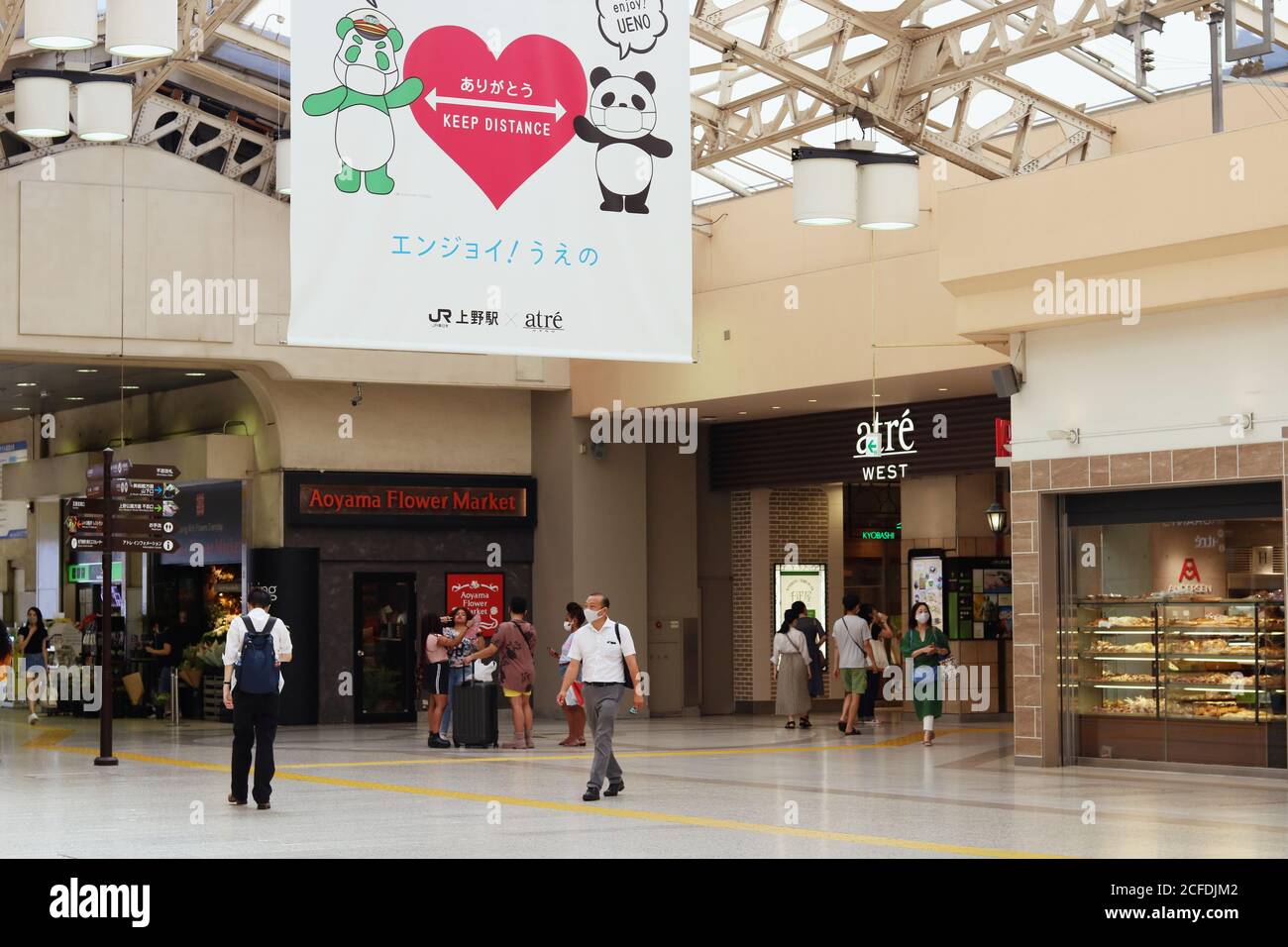 Intérieur de la station Ueno avec une grande bannière encourageant la distanciation sociale et le masque facial portant des personnes pendant l'épidémie de coronavirus. (9/2020) Banque D'Images