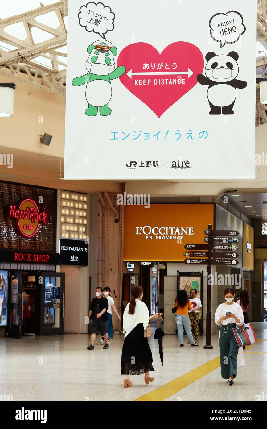 Intérieur de la station Ueno avec une grande bannière encourageant la distanciation sociale et le masque facial portant des personnes pendant l'épidémie de coronavirus. (9/2020) Banque D'Images
