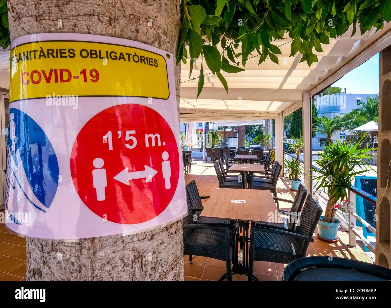 Avis de la prochaine exigence générale de masque et des tables vides Et des magasins fermés dans l'ancienne station balnéaire bien visitée de Cala d'Or au sud-est Banque D'Images