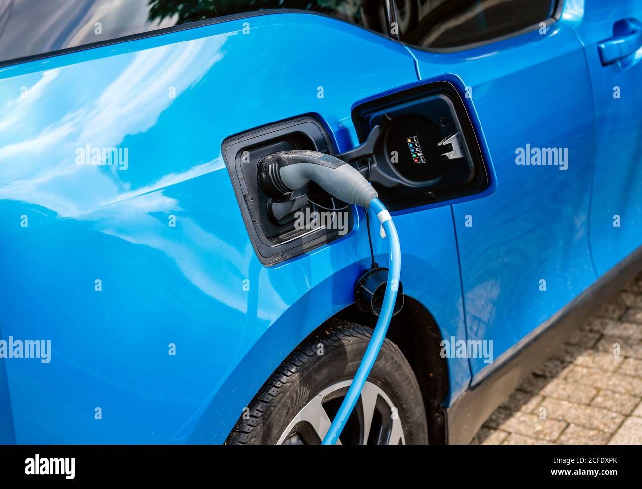 Essen, Rhénanie-du-Nord-Westphalie, Allemagne - une voiture électrique est chargée dans un parking avec câble de recharge à une station de charge. Banque D'Images