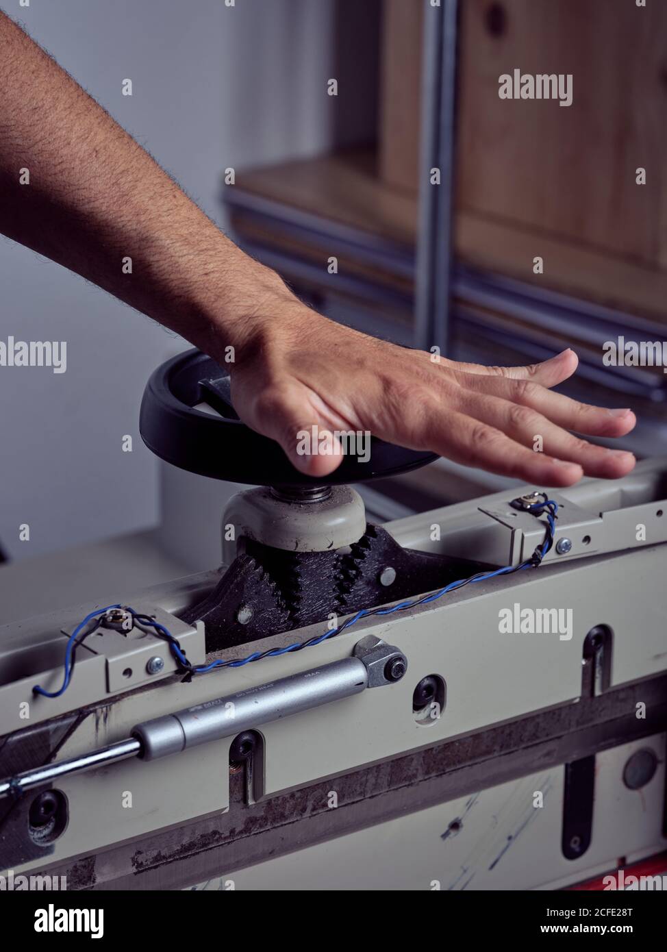 Récolte main de l'artisan compétent rotation de la roue de la poignée de reliure appuyez sur machine sur fond flou Banque D'Images
