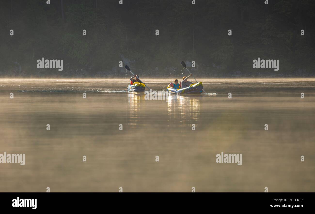 Famille avec deux kayaks (canoë) sur l'Eibsee dans le matin brouillard, brume, eau, Grainau, Garmisch-Partenkirchen, haute-Bavière, Bavière, sud Banque D'Images