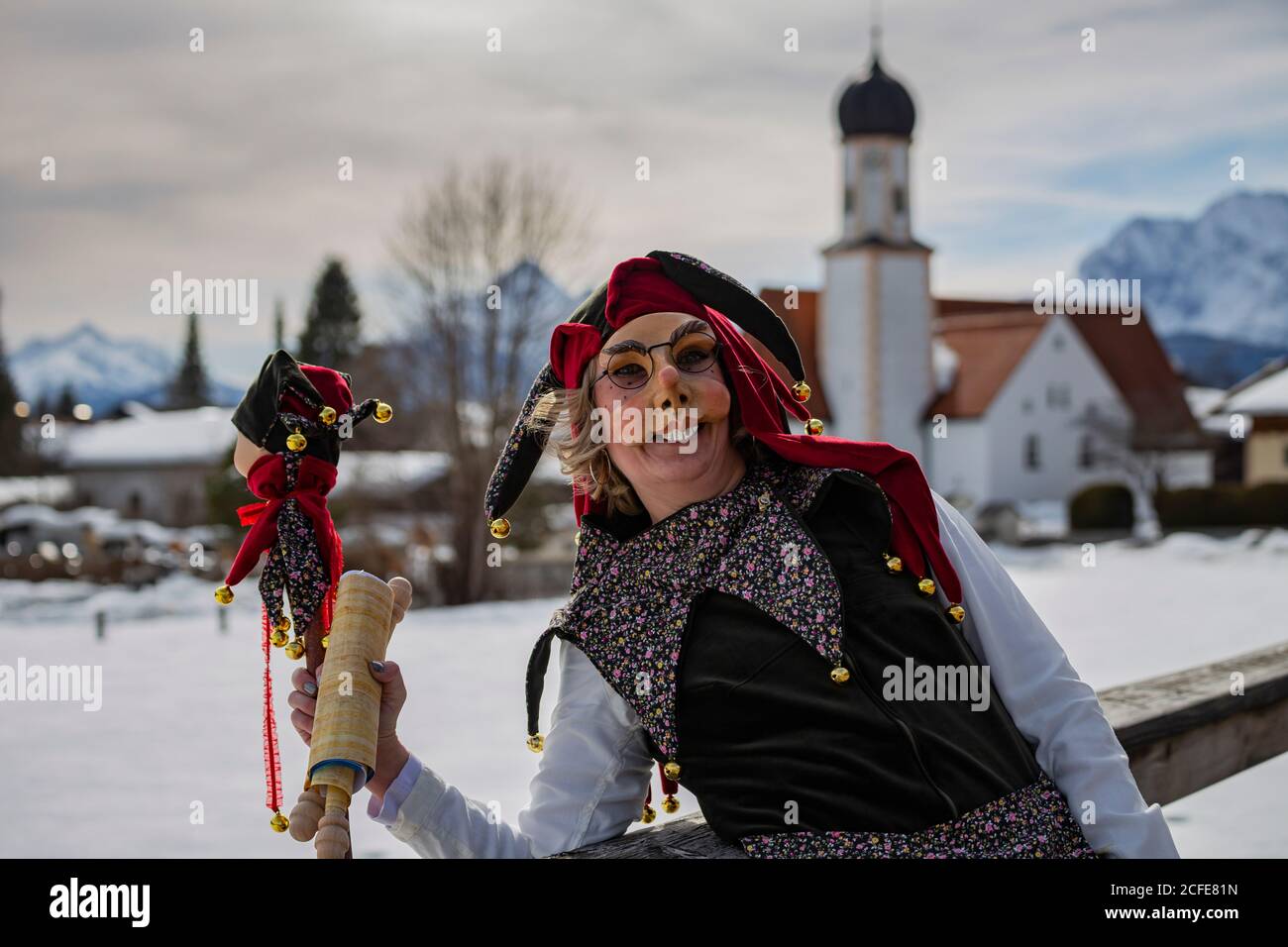 Demi-portrait de femme en costume de Mardi gras près de Wallgau, en arrière-plan l'église paroissiale de Saint-Jakob, Wallgau, Garmisch-Partenkirchen, Upper Banque D'Images