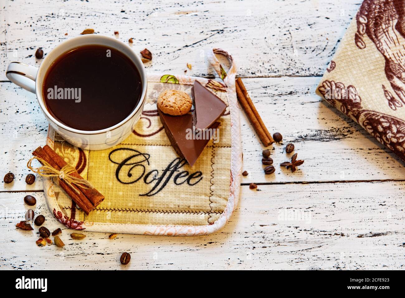 Tasse à café, chocolat, grains de café et épices sur table en bois blanc. Bon petit déjeuner ou pause-café sur fond. Banque D'Images