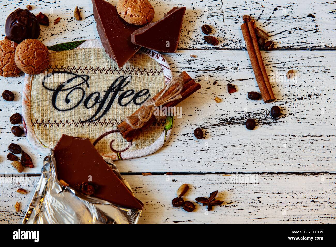 Tasse à café, chocolat, grains de café et épices sur table en bois blanc. Bon petit déjeuner ou pause-café sur fond. Banque D'Images