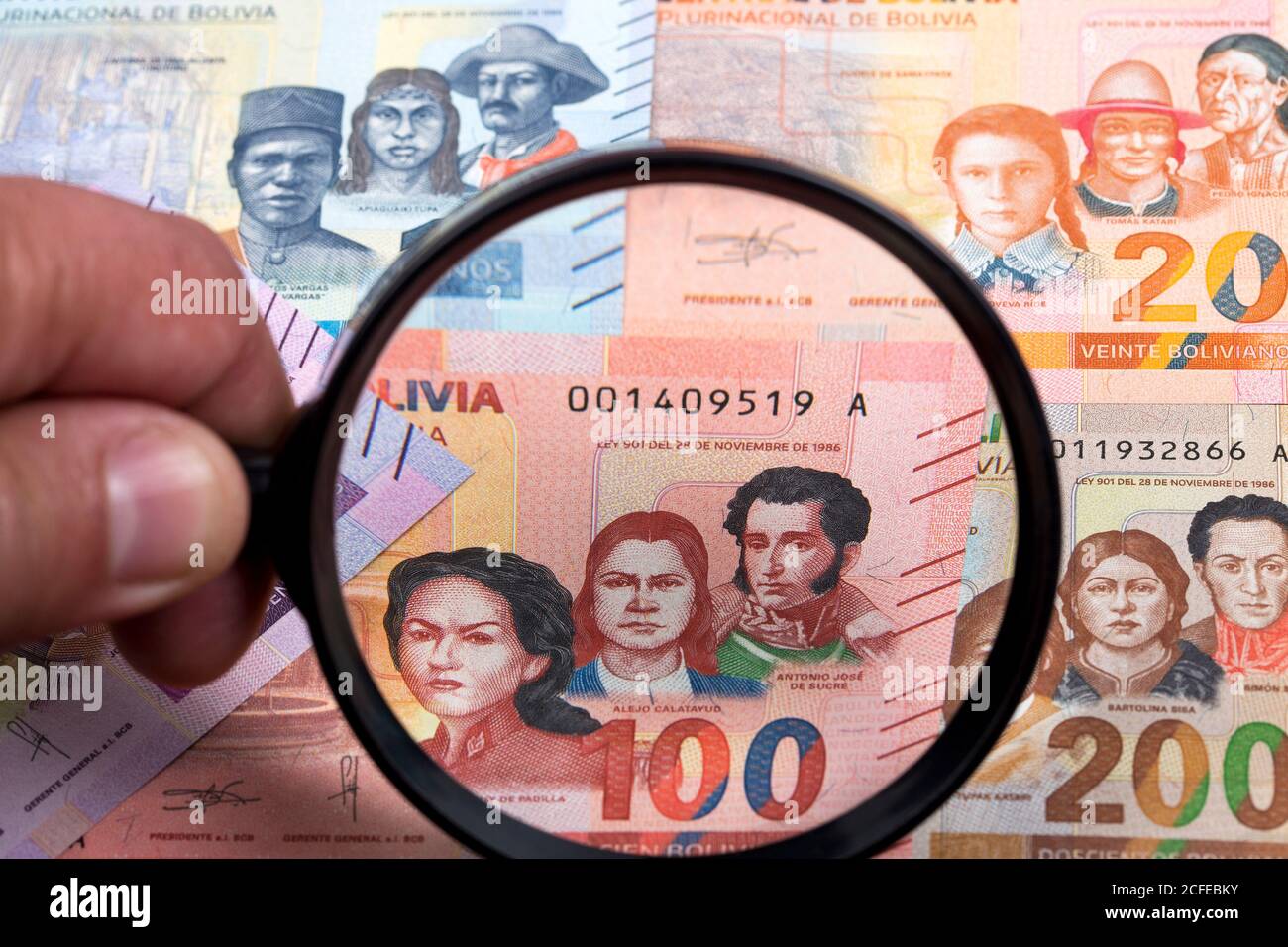 L'argent bolivien dans une loupe un contexte d'affaires Banque D'Images
