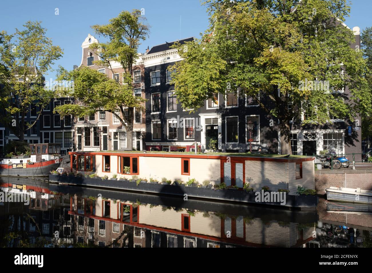 Maisons et péniche miroir dans l'eau du Prinsengracht juste en face de la maison d'Anne Frank à Amsterdam, tôt le matin Banque D'Images