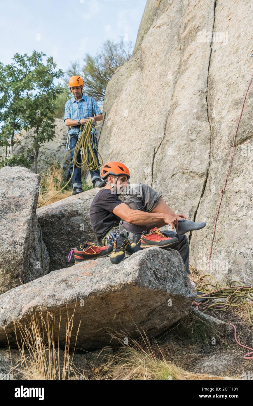 Un grimpeur de roche met ses chaussures d'alpinistes à commencez à grimper Banque D'Images