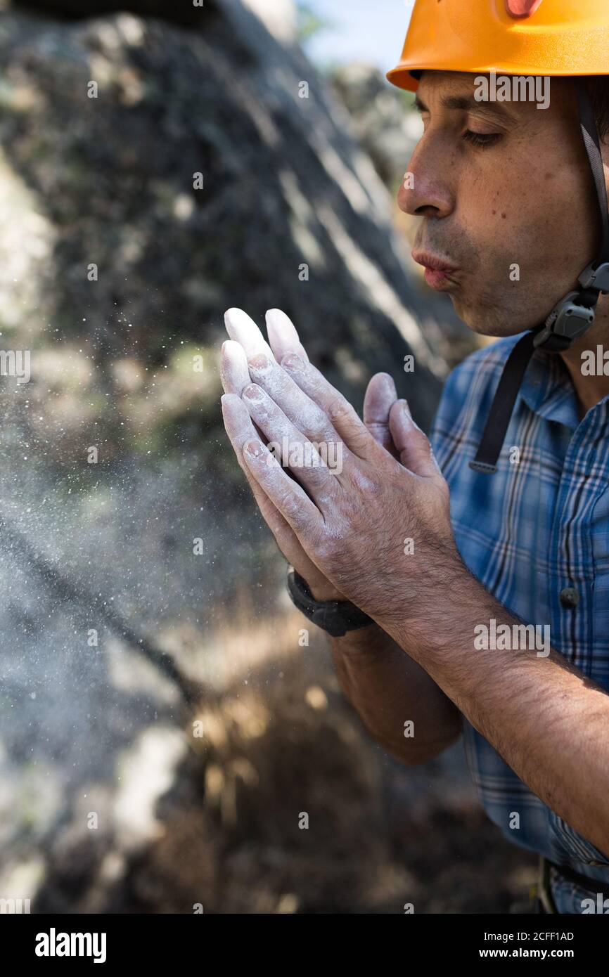 Un grimpeur souffle de la poudre de craie de ses mains Banque D'Images