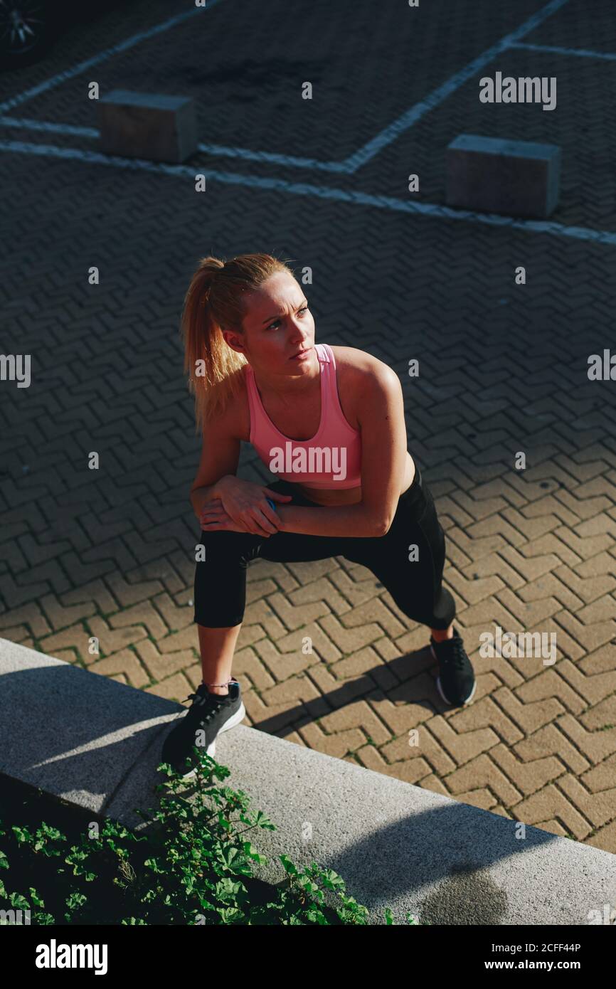 Jeune femme blonde faisant des exercices d'étirement après une séance de course à pied Banque D'Images