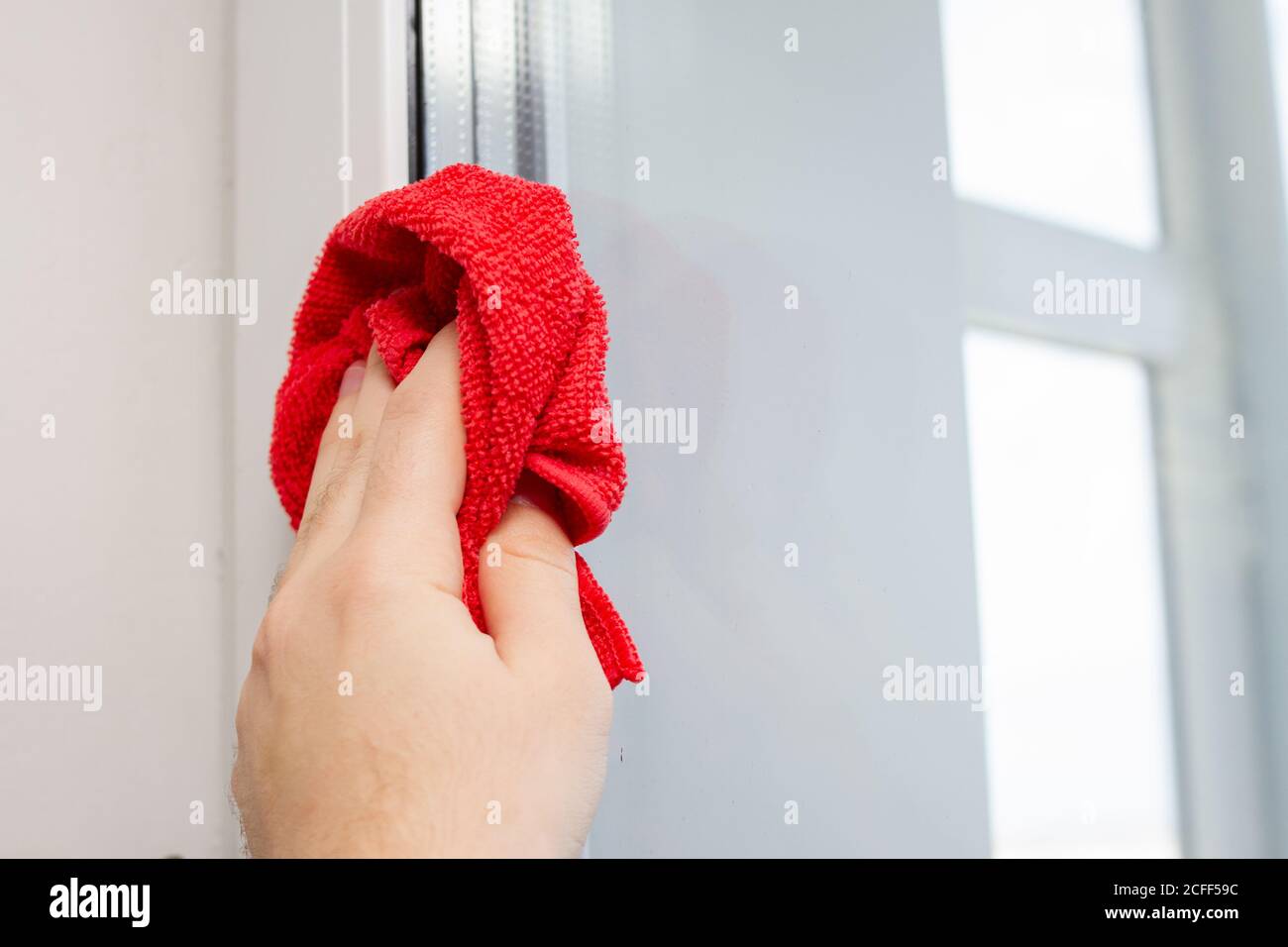 nettoyage de la vitre à l'aide d'un chiffon en microfibre rouge Banque D'Images