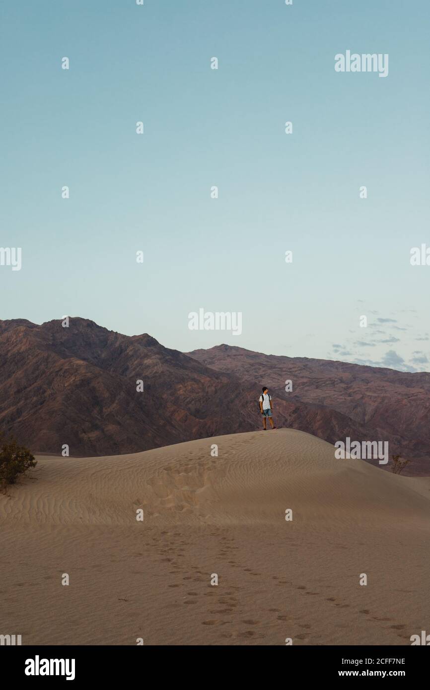 jeune homme en chemise blanche marchant dans le désert à sec Dunes de sable dans la vallée de la mort Banque D'Images