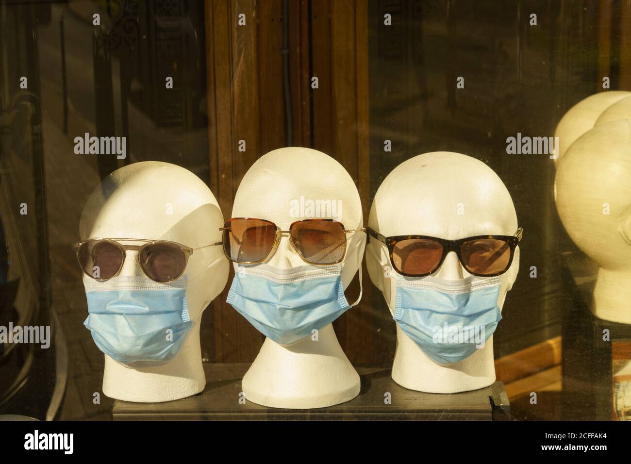 Une vitrine d'un opticien présente des répliques blanches de têtes avec des  lunettes de soleil et des masques faciaux, Harrogate, North Yorkshire,  Angleterre, Royaume-Uni Photo Stock - Alamy