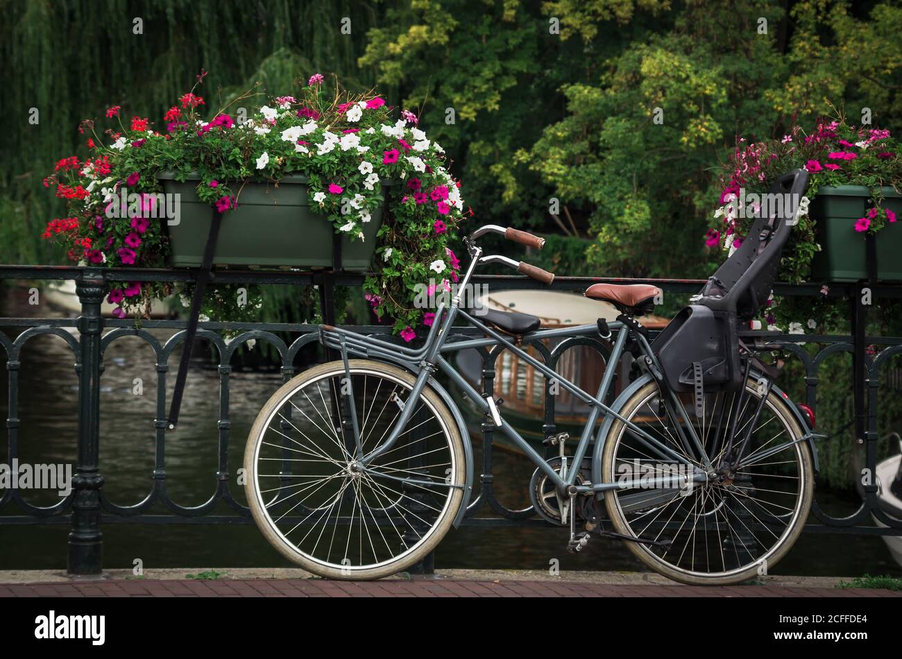 Vélo stationné sur un pont au-dessus d'un chenal. Scène typique d'Amsterdam. Banque D'Images