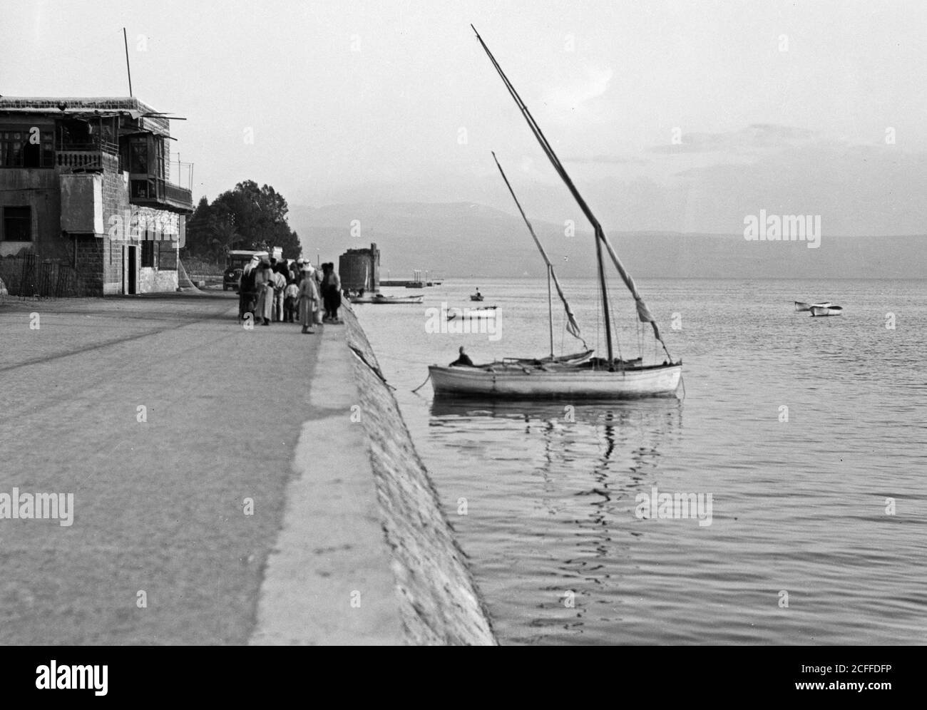 Légende originale: Front de mer de Tiberias (avec voilier blanc) - emplacement: Israël--Tiberias ca. 1934-1939 Banque D'Images