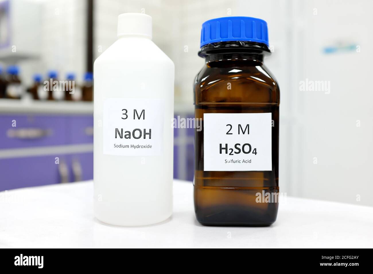 Concentration sélective de la base d'hydroxyde de sodium et de la solution  d'acide sulfurique dans un flacon en verre brun et en plastique à  l'intérieur d'un laboratoire de chimie. Arrière-plan blanc Photo