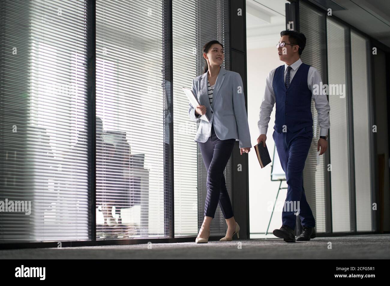 deux hommes d'affaires asiatiques sur le chemin de la rencontre en marchant dans le bureau Banque D'Images
