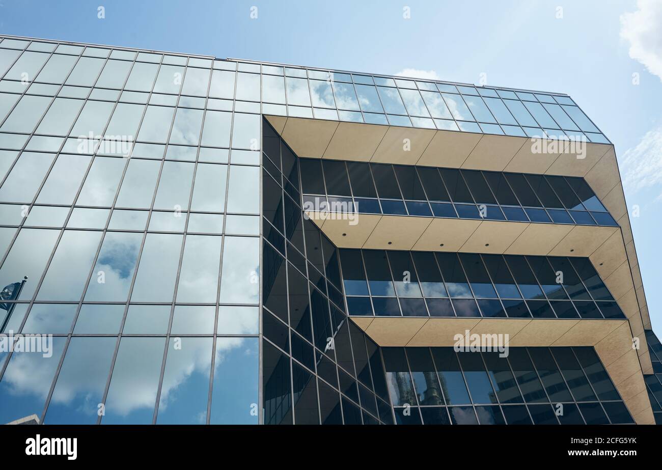 Depuis le dessous structure complexe géométrique étonnante avec de grandes fenêtres réfléchissantes Nuages blancs dans le ciel du Texas Banque D'Images