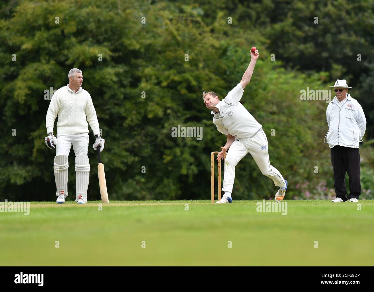 Un joueur en action dans le Derbyshire et Cheshire Cricket League match entre Dinting et Whaley Bridge. Banque D'Images