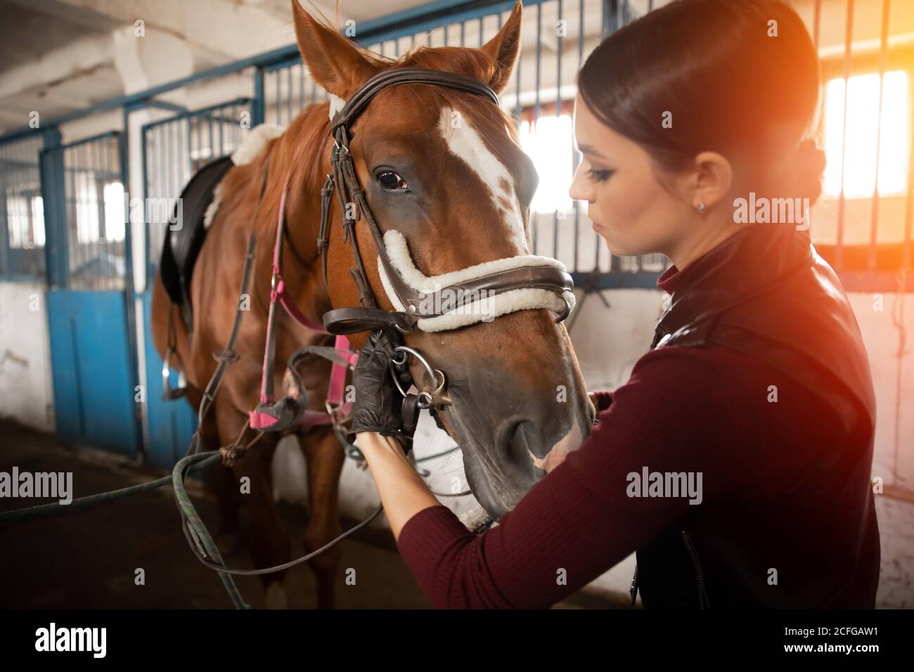 Une jeune femme pilote met une selle de cheval en décrochage Banque D'Images