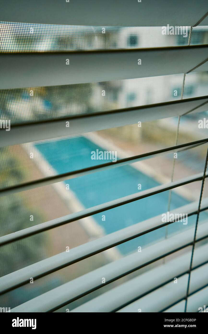 Vue d'en haut de la piscine dans la cour à travers le métal jalousie et  moustiquaire sur la fenêtre Photo Stock - Alamy