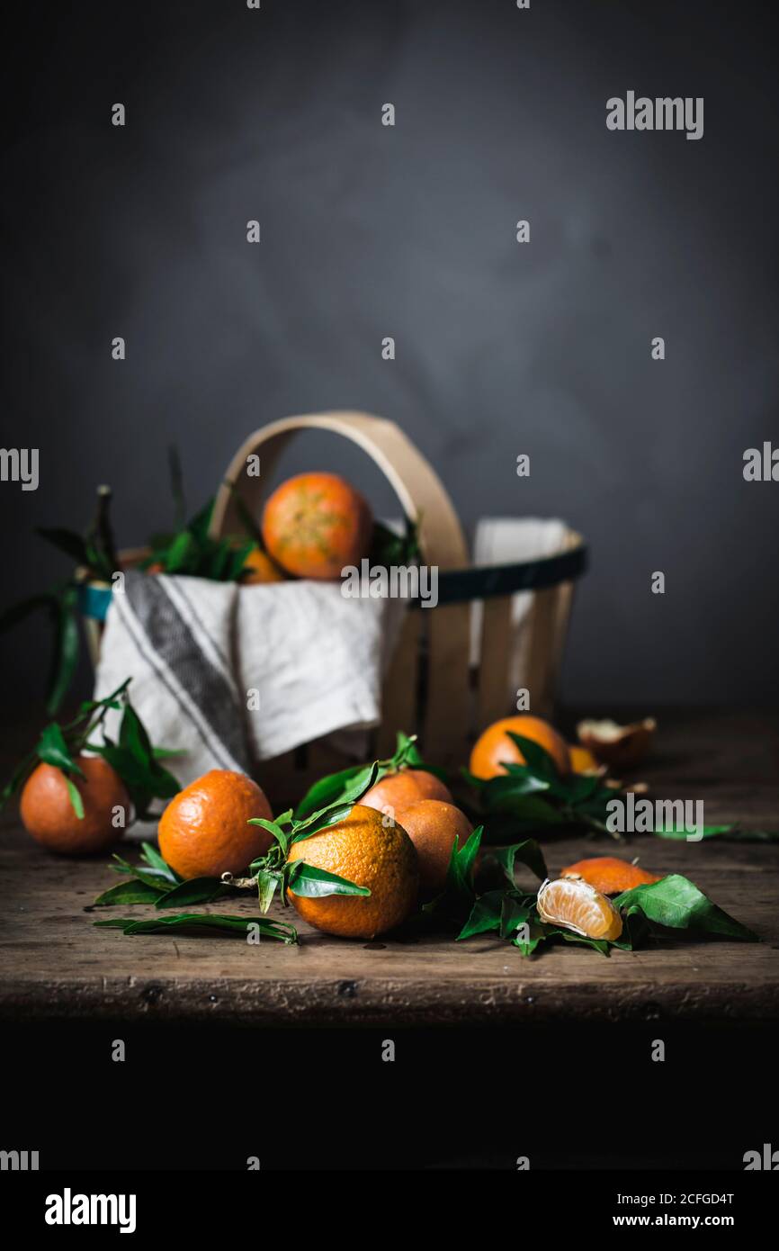 Mandarines d'orange mûres et panier avec serviette sur bois rugueux tableau Banque D'Images