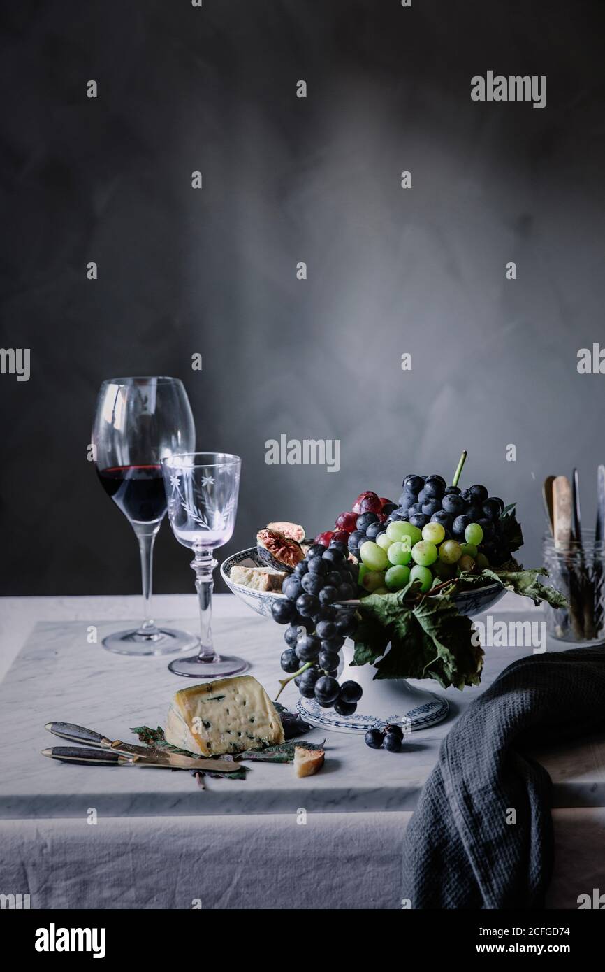 Raisins avec vin et fromage bleu servis sur la table pour dîner Banque D'Images