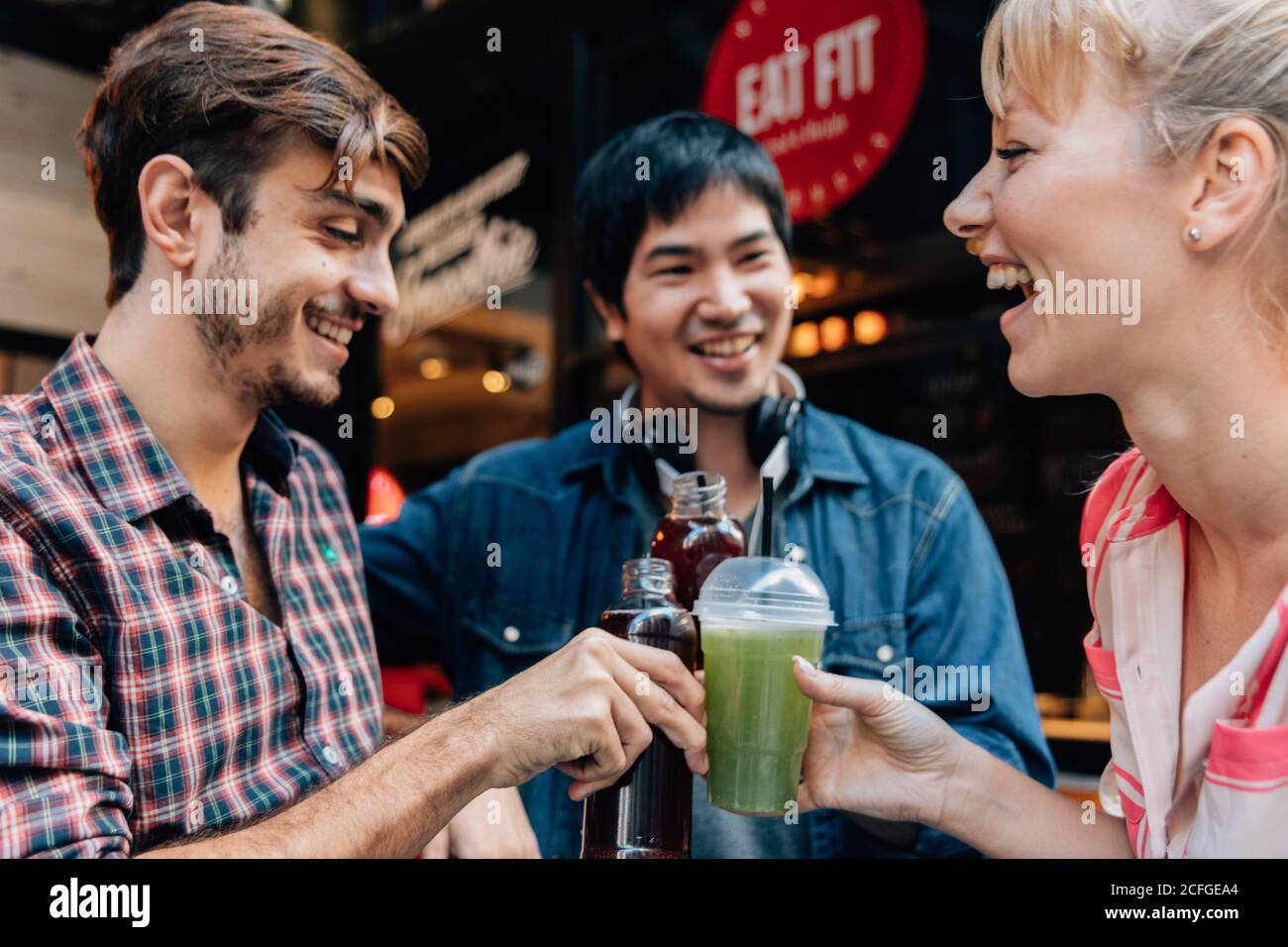 Personnes assises en train de boire un verre en souriant et avec ses ...