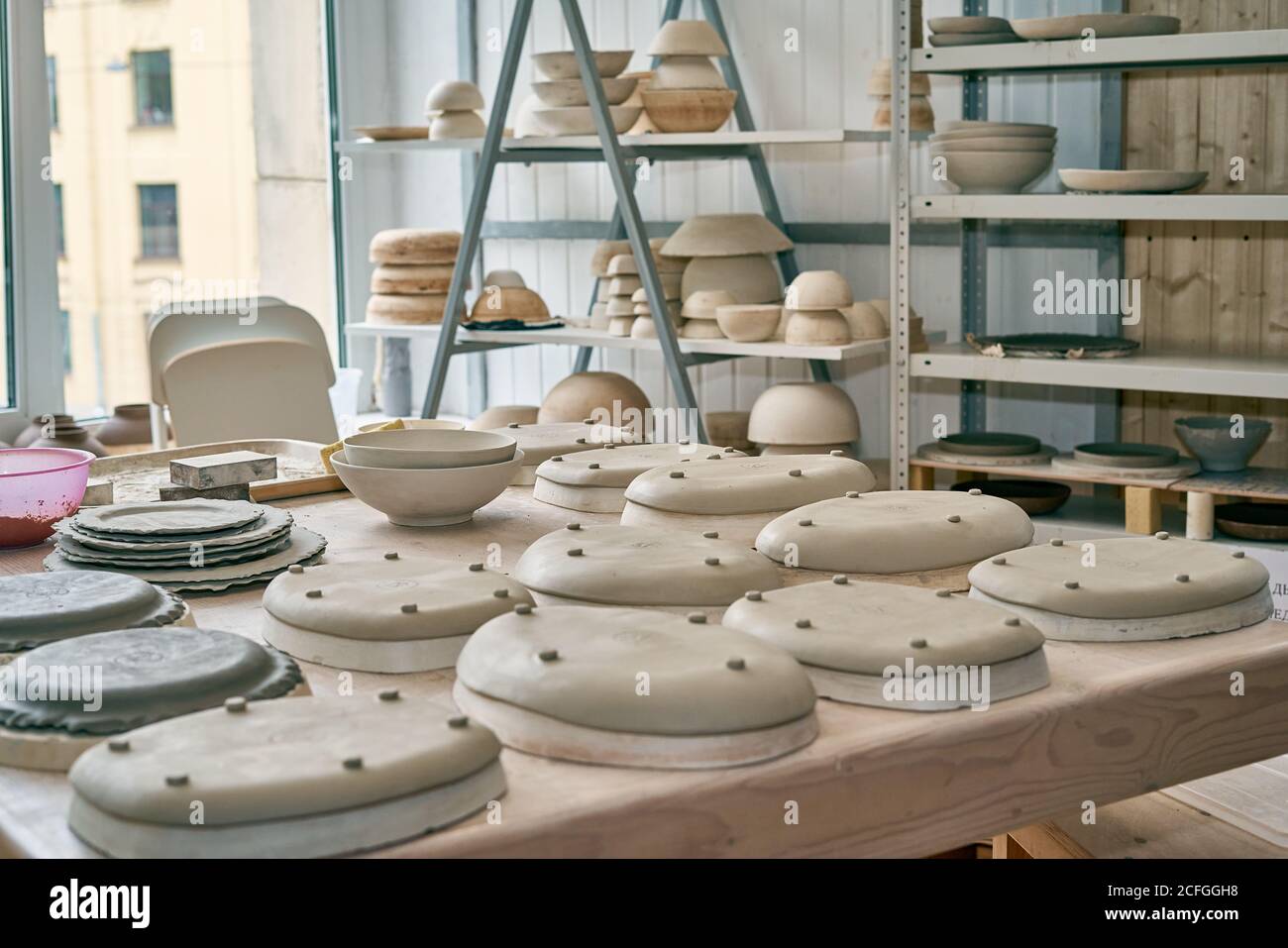 Fabrication de produits céramiques, pièce à usiner. Fermez l'arrière-plan  avec des pièces en céramique sur la table de la vaisselle contre la fenêtre  Photo Stock - Alamy