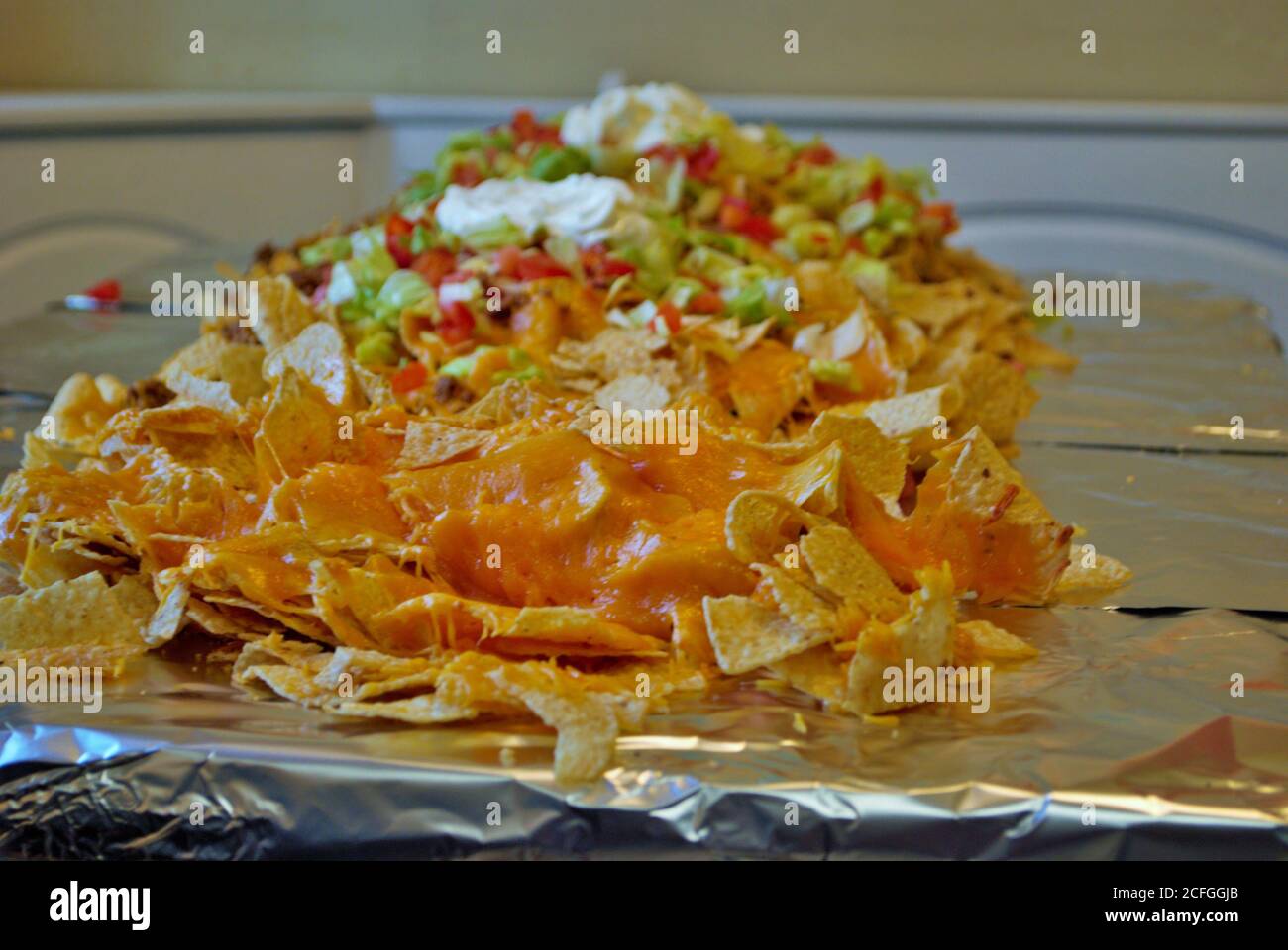 Table de cuisine Nacho table enveloppée de papier aluminium et couverte avec nachos Banque D'Images