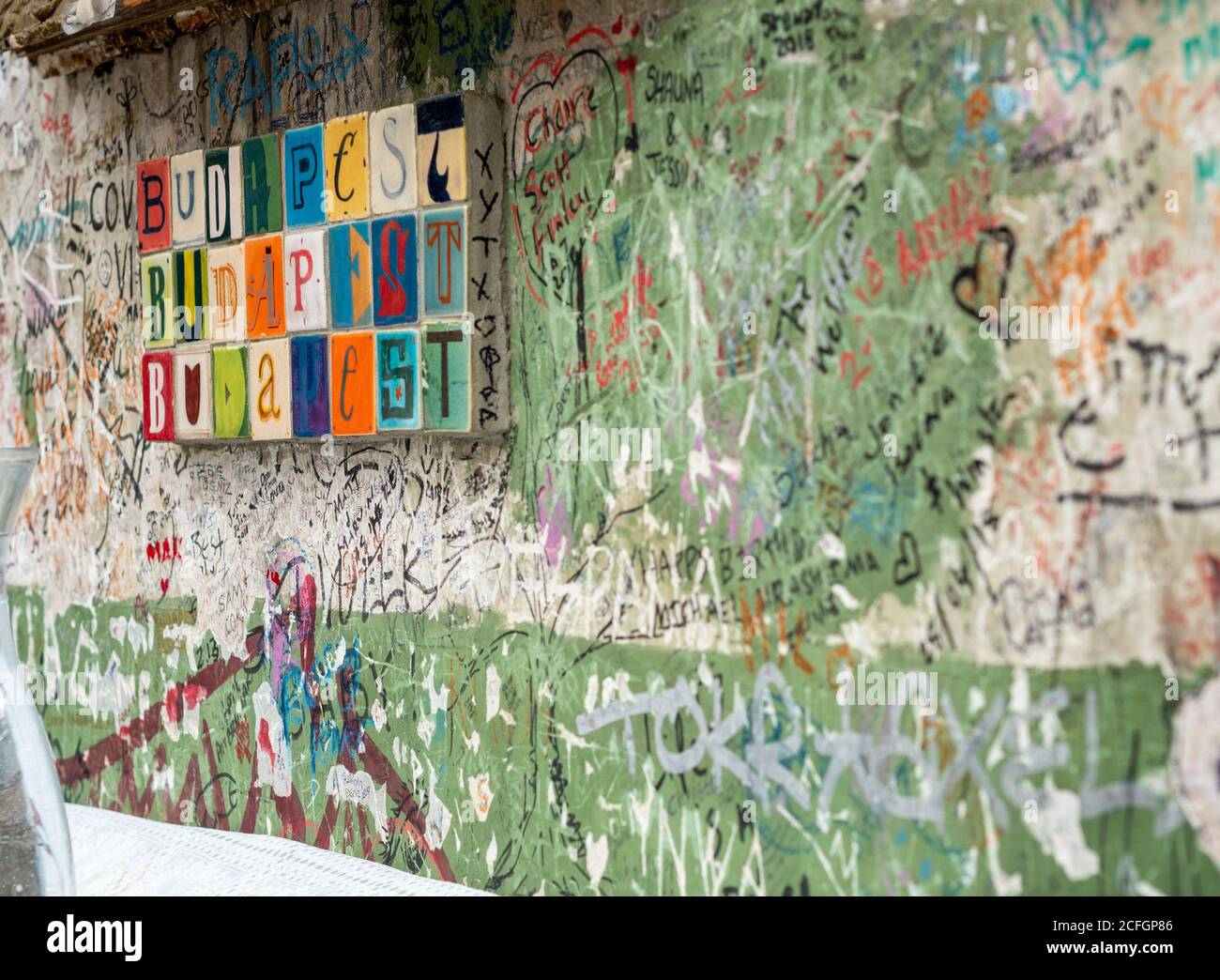 Les carreaux colorés font 3 fois une place à Budapest sur un mur d'un bar en ruine recouvert de gribouts de mécène. Banque D'Images