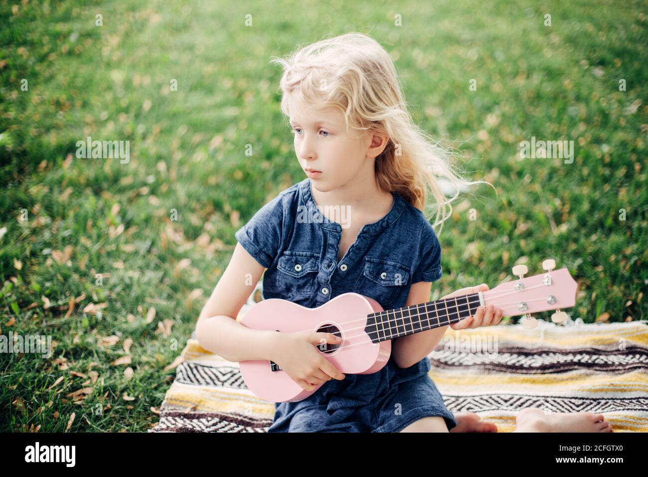 Fille blonde pensive jouant de la guitare rose jouet extérieur. Enfant  jouant de la musique et chant dans le parc. Activités de loisirs pour  enfants. Authentique et sincère Photo Stock - Alamy