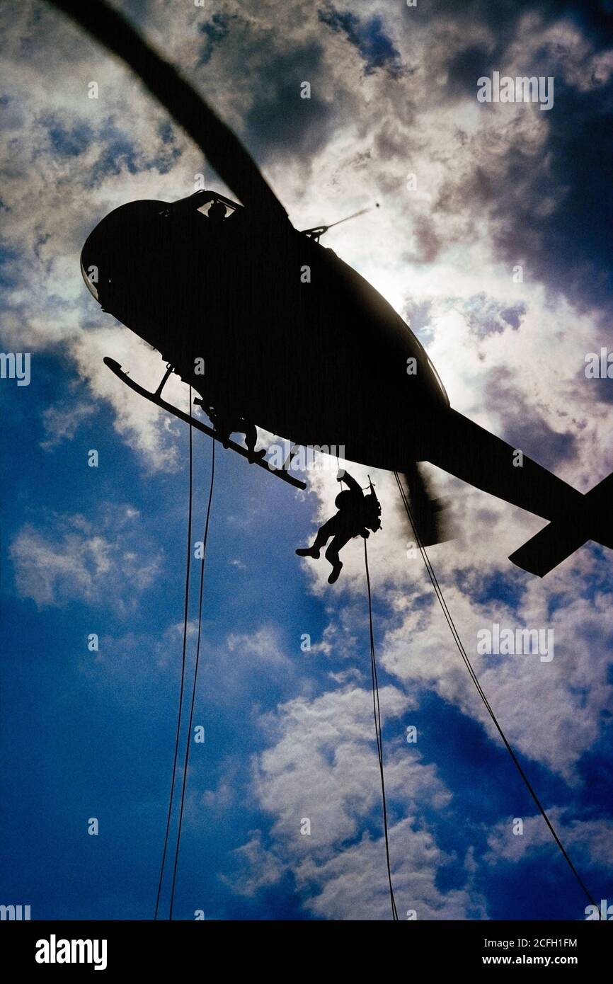 ANNÉES 1970, DEUX SOLDATS DE L'ARMÉE AMÉRICAINE ONT FAIT UNE DESCENTE EN RAPPEL D'UN HUEY HÉLICOPTÈRE MILITAIRE BELL UH-1D SILHOUETÉ DANS UN CIEL NUAGEUX ET LUMINEUX - KA4714 BLE001 HARS VITESSE DE L'ESPACE DE COPIE RURAL PAR RAPPORT À LA PLEINE LONGUEUR PHYSIQUE FITNESS PERSONNES INSPIRATION DANGER HOMMES RISQUE CONFIANCE BUTS DE TRANSPORT SUCCÈS MARINE BRIGHT FIGHTER AVENTURE AVIONS STRATÉGIE DE FORCE A DÉFAIT L'EXCITATION DE COURAGE LEADERSHIP DE CONNAISSANCES ANGLE BAS PUISSANT HÉLICOPTÈRE DESCENDANT FIERTÉ AVIATION OCCUPATIONS UNIFORMES MOUVEMENT FLOU CONCEPTUEL AGRESSION DE PRÉCISION JEUNE ADULTE HOMME NUAGEUX SORTIE IROQUOIS À L'ANCIENNE Banque D'Images