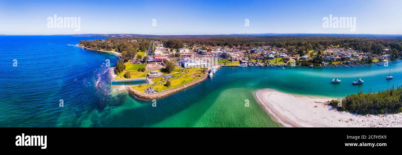 Front de mer de la ville de Huskisson sur la baie de Jervis avec le delta de la rivière Curambene creek entrant dans l'océan Pacifique - panorama aérien. Banque D'Images