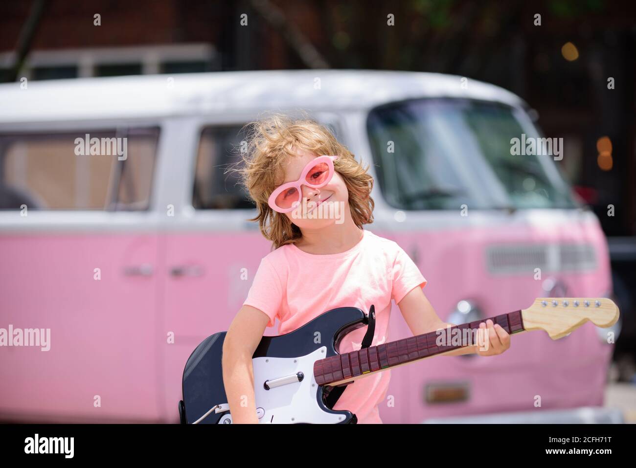 Enfant drôle avec guitare rock. Un petit garçon de campagne américain  jouant de la musique Photo Stock - Alamy