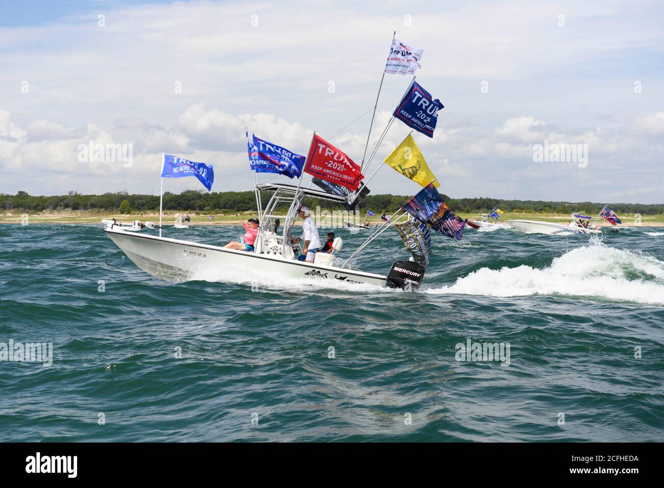 Lakeway, Texas États-Unis 5 septembre 2020 : les drapeaux de Trump volent à travers des vagues extrêmement lourdes remuées par des bateaux à proximité lors d'une parade de bateau pour montrer le soutien à l'US Presd Donald Trump. Le week-end de la fête du travail sur un lac du Texas central a attiré des centaines de motomarines de toutes tailles. Plusieurs bateaux ont été submergés dans les énormes ébarges qui ont été piétinés par la flottille, mais aucune blessure n'a été signalée. Crédit : ©Bob Daemmrich/Alamy Live News Banque D'Images