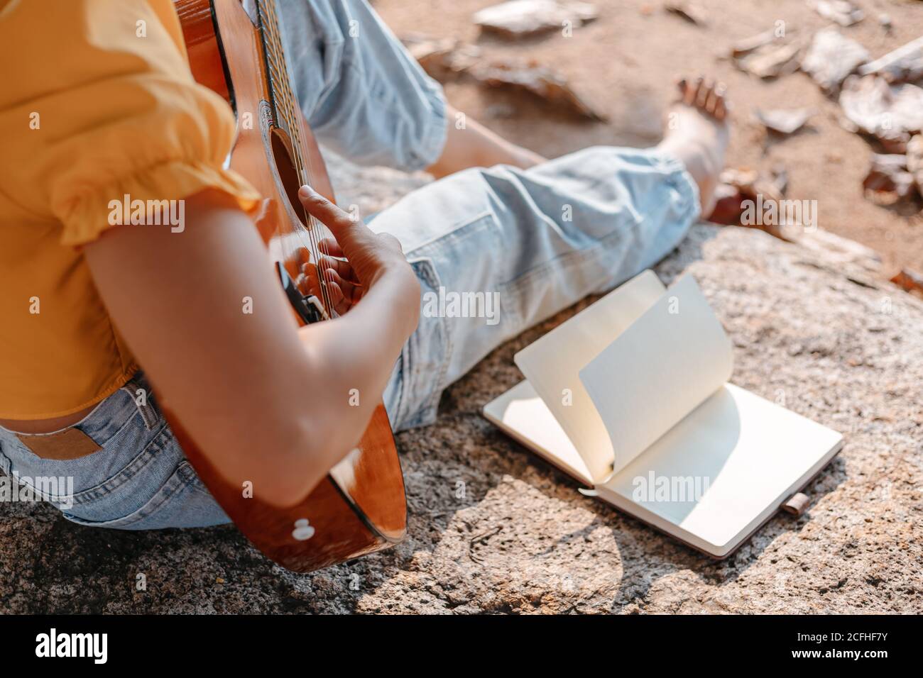 notes, paroles dans le livre sur la pierre dans les parcs à côté des femmes jouent de la guitare. Banque D'Images