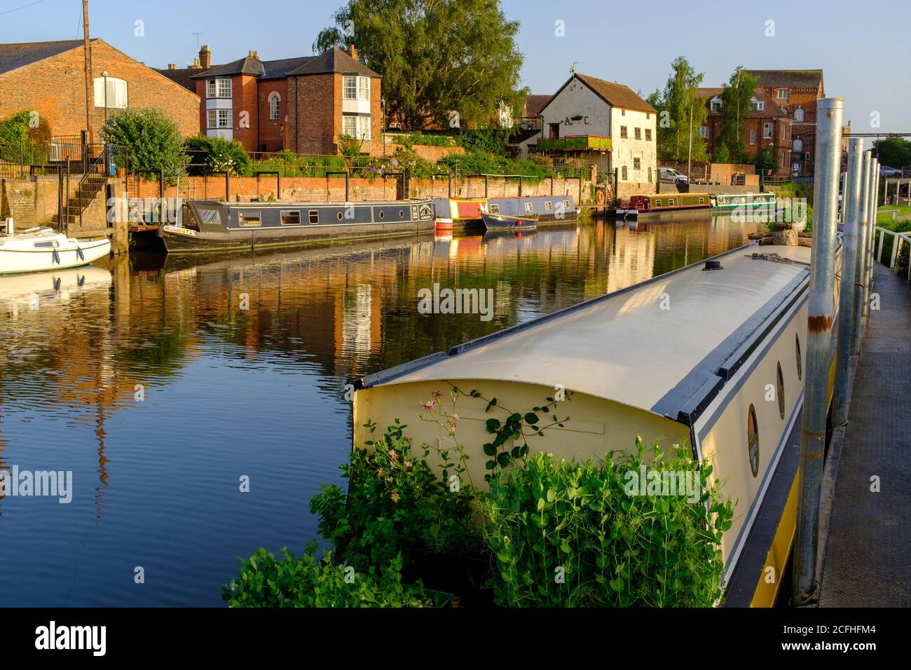 Canots à canots (Narrowboats) sur la rivière Avon lors d'une soirée en milieu d'été, Tewkesbury, Angleterre Banque D'Images
