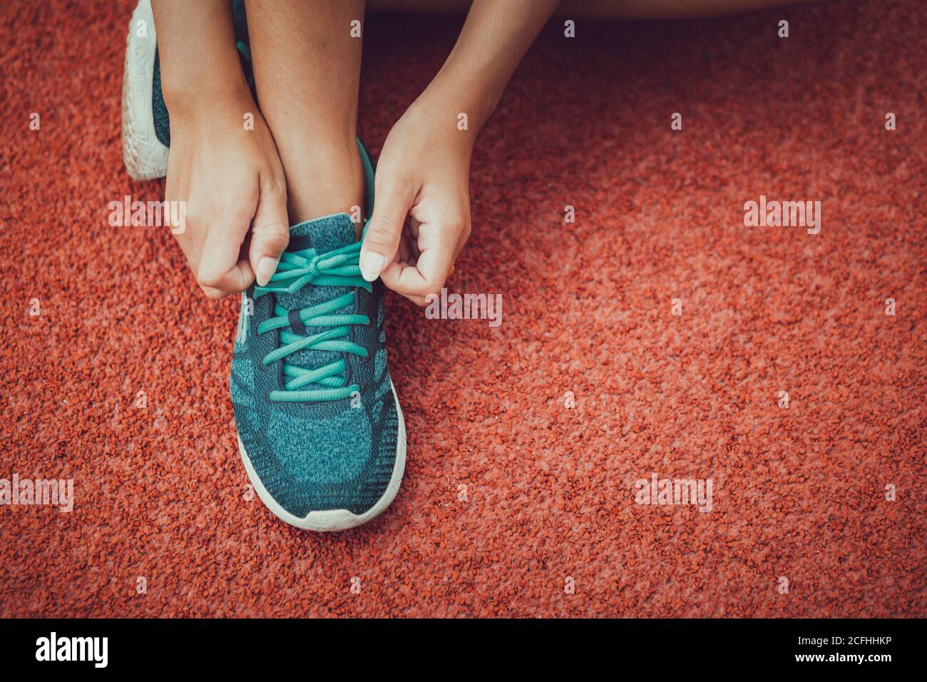 Jeune fille brune attrayante enlaçage ses chaussures de sport. Banque D'Images