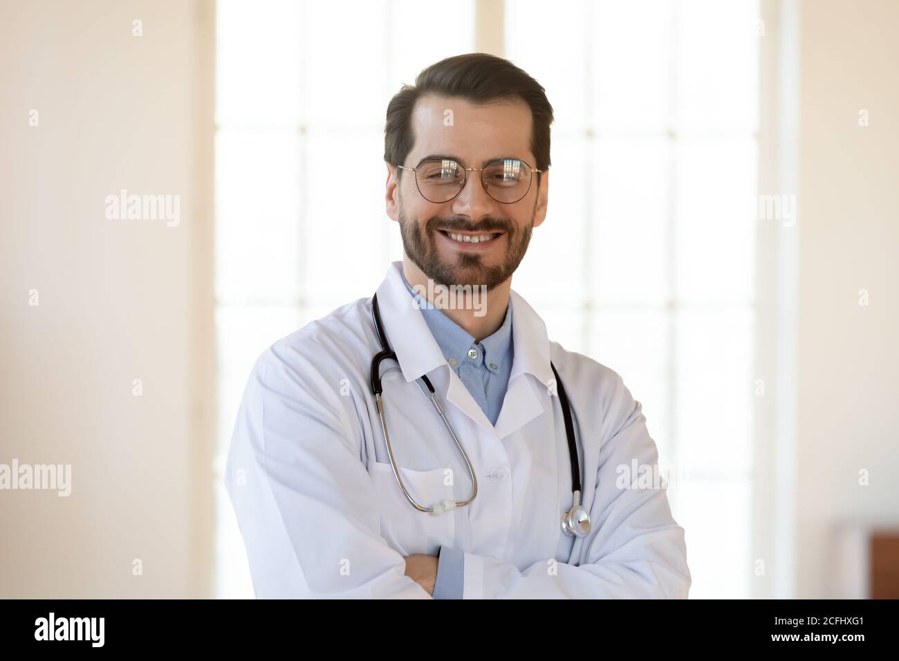 Portrait de tête souriant jeune homme médecin portant des lunettes Banque D'Images