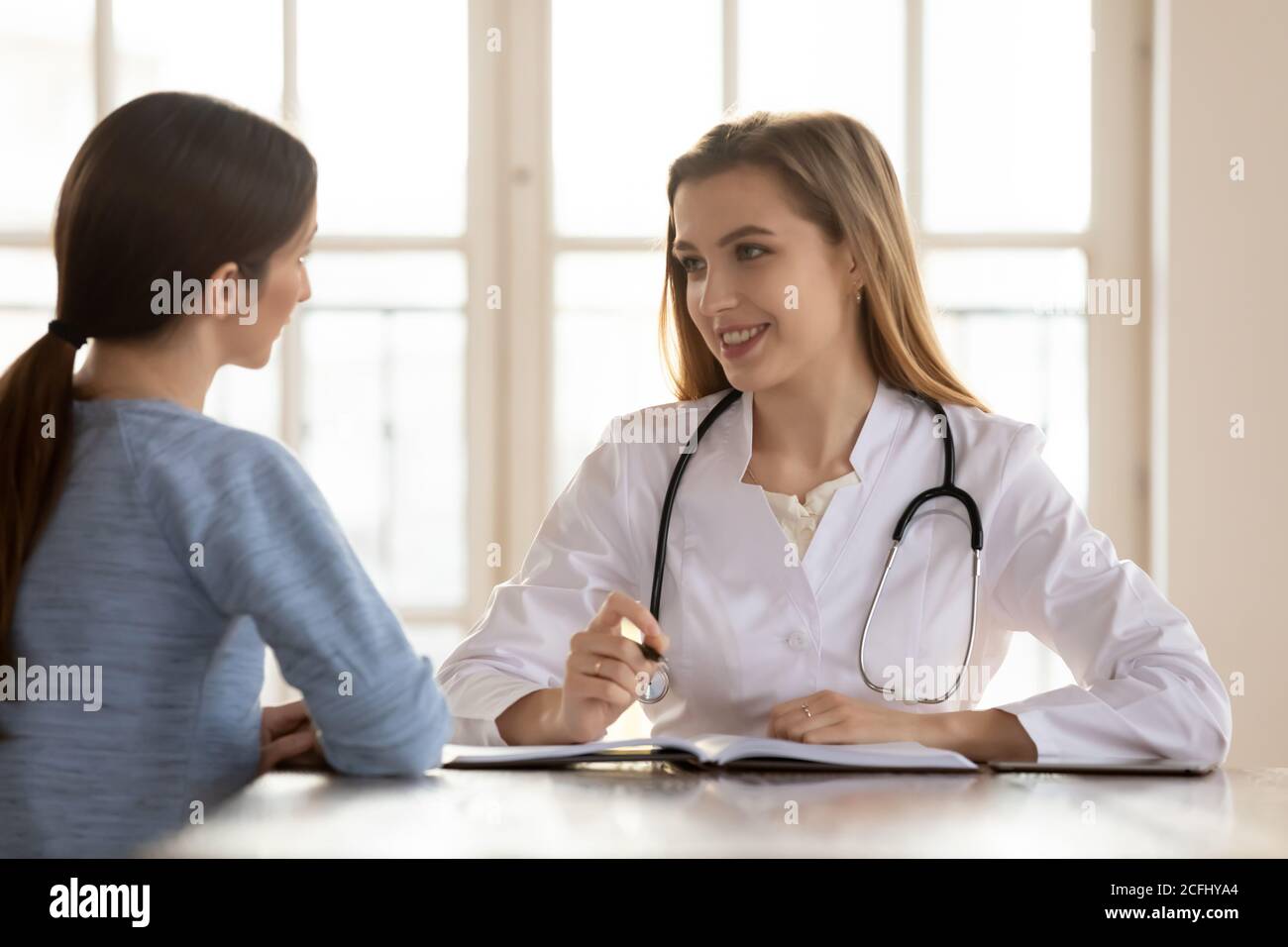 Femme souriante médecin thérapeute consultant le patient sur rendez-vous médical Banque D'Images