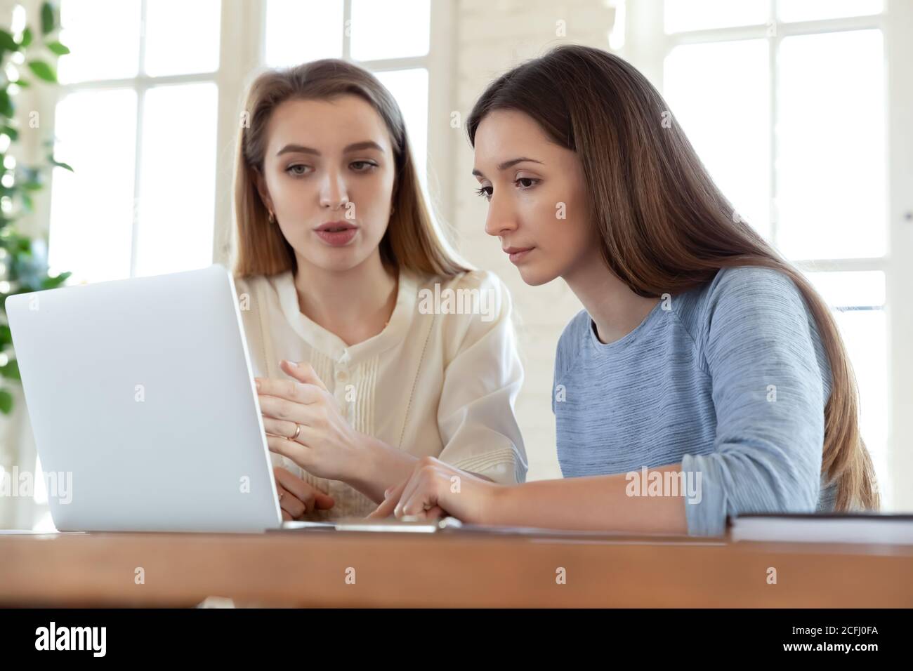 Femme d'affaires mentor enseignant stagiaire, pointant vers l'écran de l'ordinateur portable, expliquant Banque D'Images
