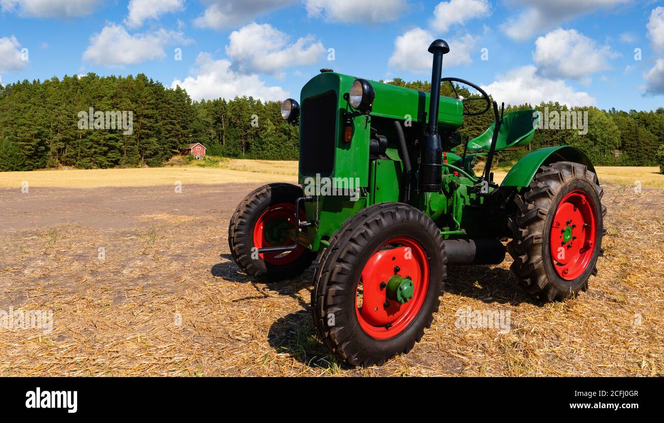 Vieux tracteur sur le champ près de la ferme Banque D'Images