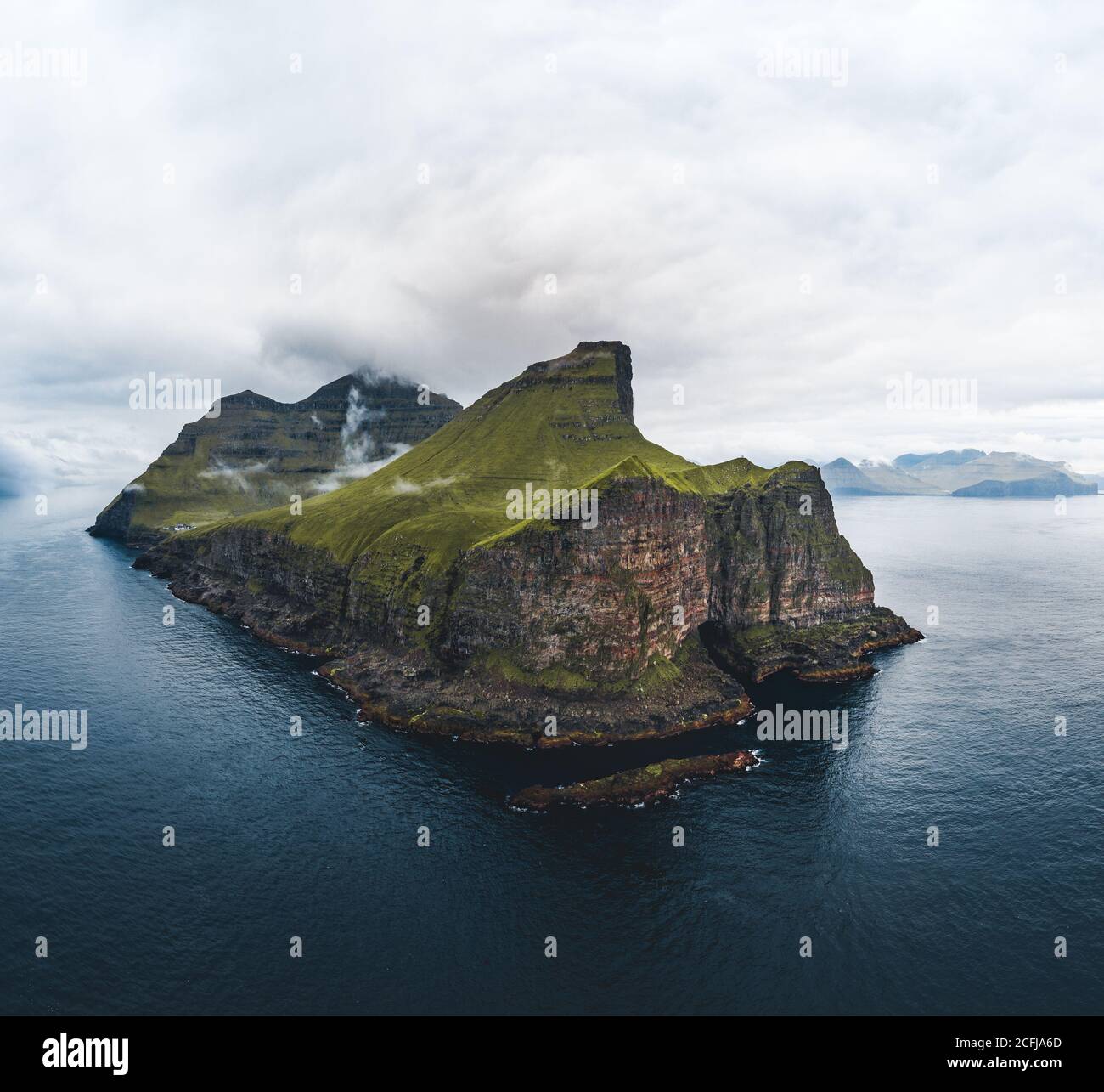 Vue aérienne sur les îles de Kalsoy sur les îles Féroé. Panorama aérien d'un petit phare blanc situé au bord d'une immense falaise et de l'île Banque D'Images