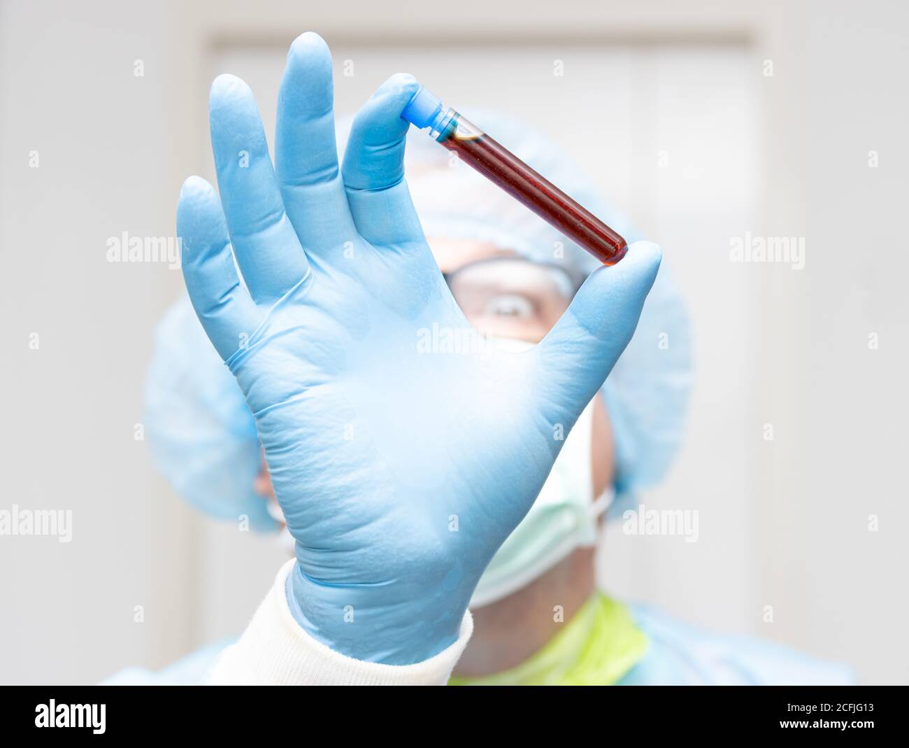 Le médecin tient le tube à essai avec un sang de test, se concentrer sur une main, visage flou. Recherche de sang de patient, Banque D'Images