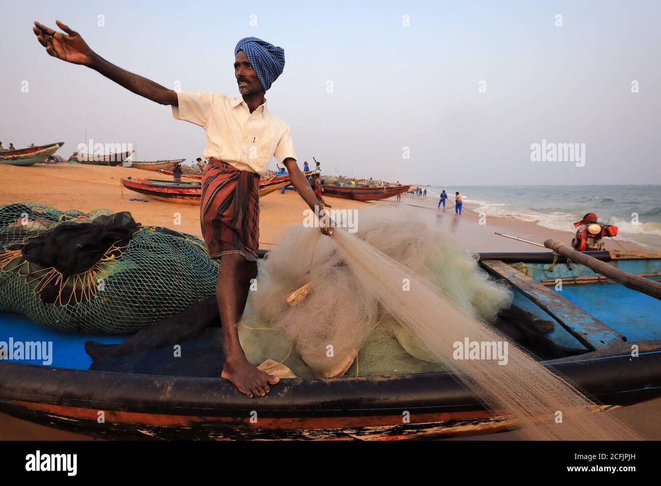 Pêcheur sur la plage près de la colonie de pêcheurs traditionnelle de Puri, Odisha, Inde Banque D'Images