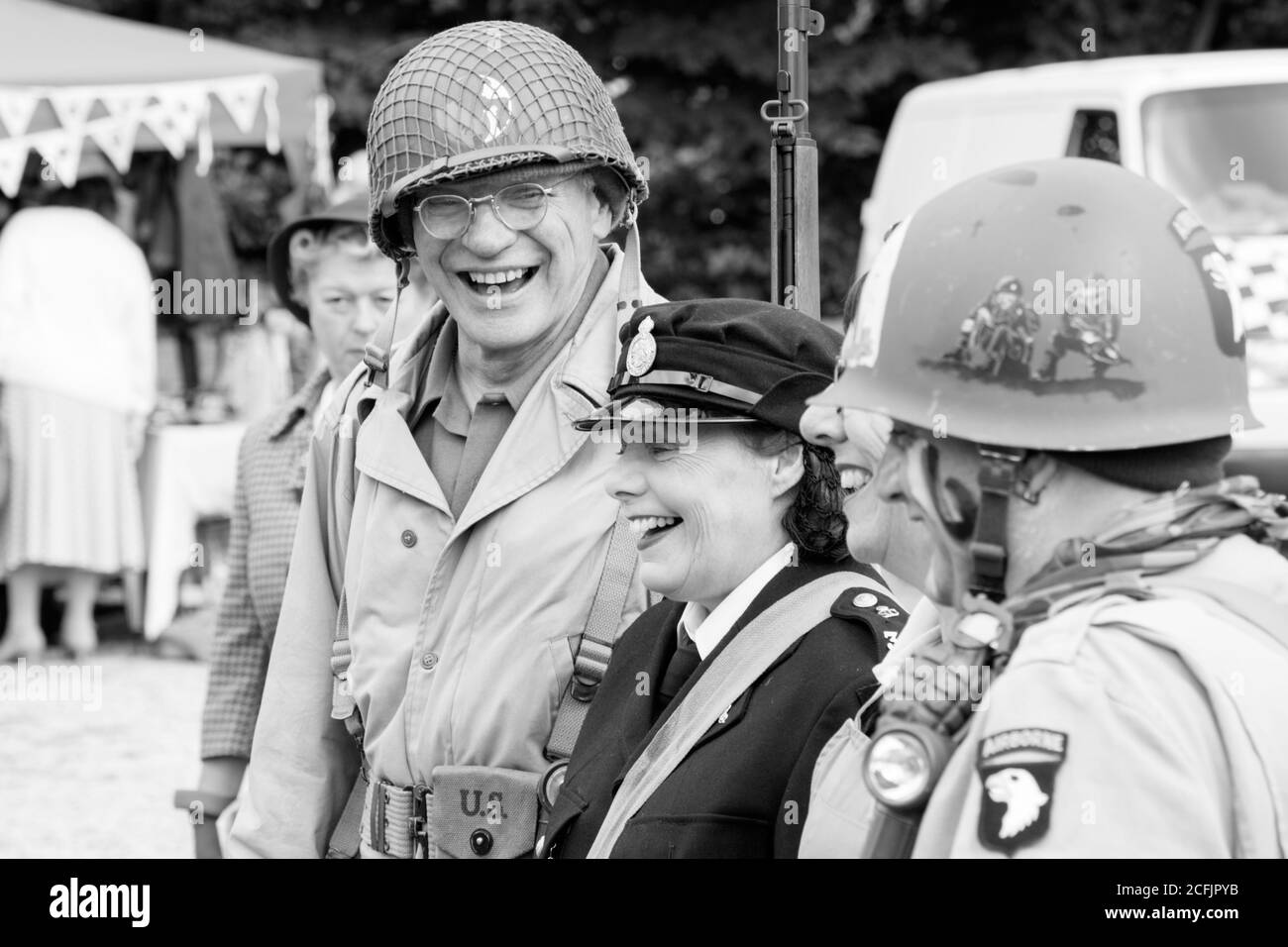 Un groupe d'hommes et de femmes vêtus d'uniformes militaires américains lors d'un week-end de 1940s, Pateley Bridge, Nidfoot, North Yorkshire, Angleterre, ROYAUME-UNI. Banque D'Images