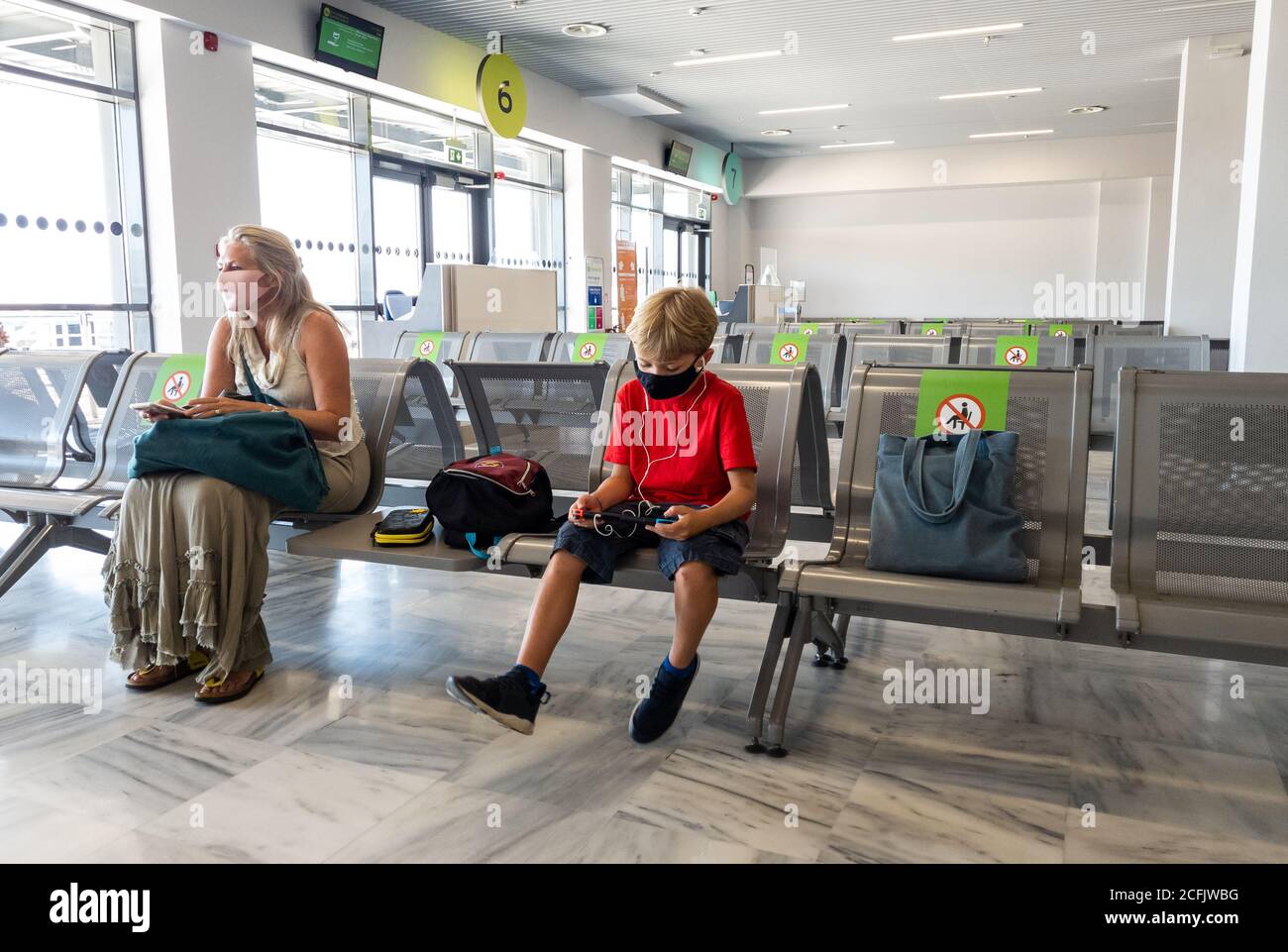 Les vacanciers attendent leur vol de retour dans le salon de départ de l'aéroport d'Aktion. Banque D'Images