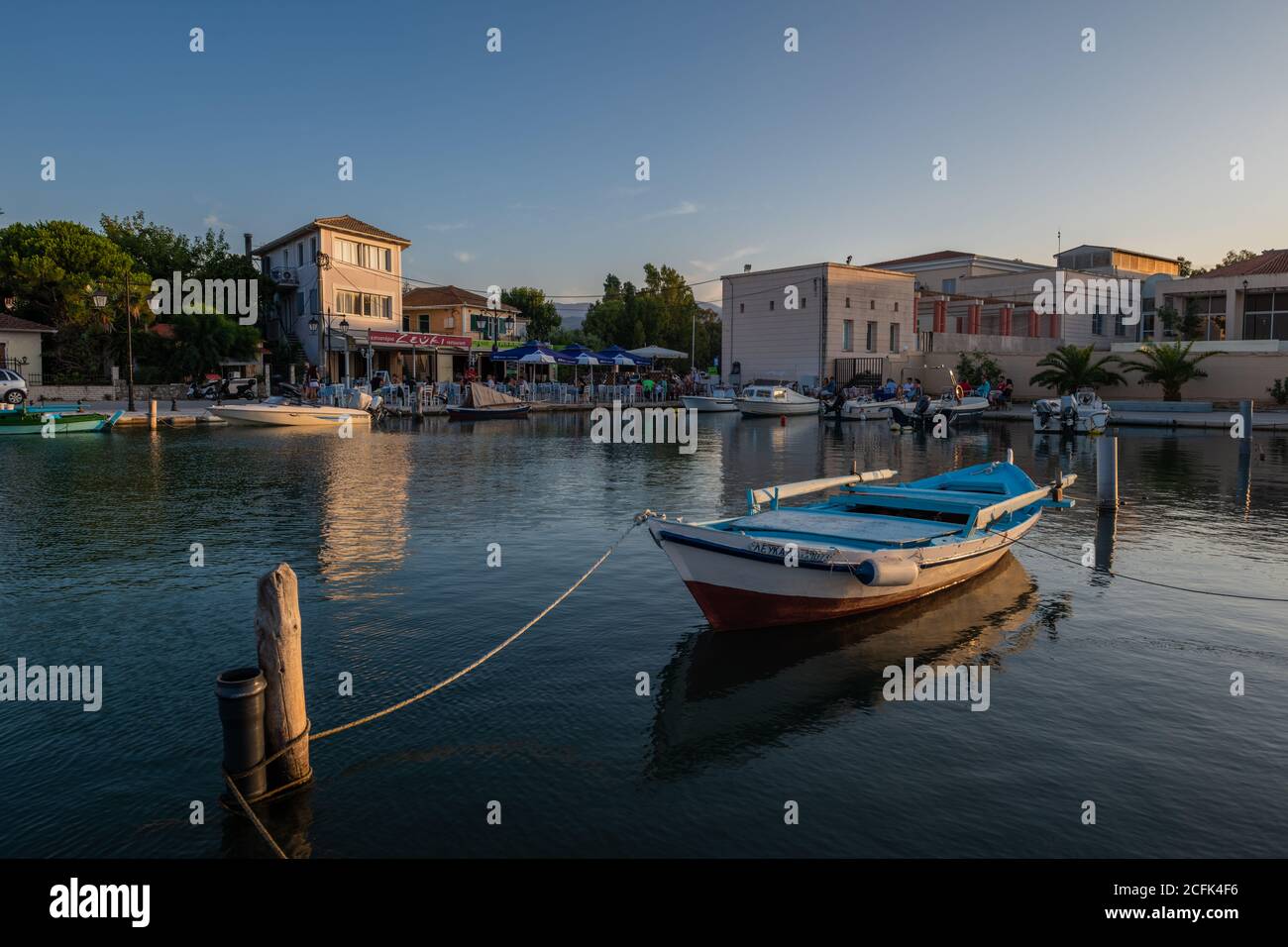 Une vue sur la ville de Lefkada, la capitale de l'île, avec des bâtiments et des bateaux qui jettent un reflet sur l'eau fixe du chenal. Banque D'Images