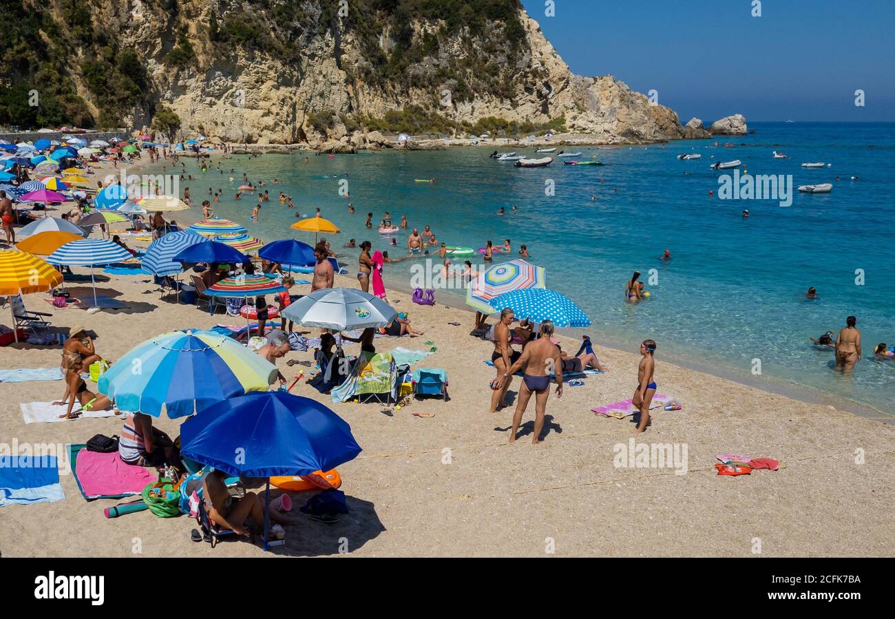 Les touristes appréciant une belle journée chaude d'été sur la plage de ce beau complexe de vacances en famille. Banque D'Images